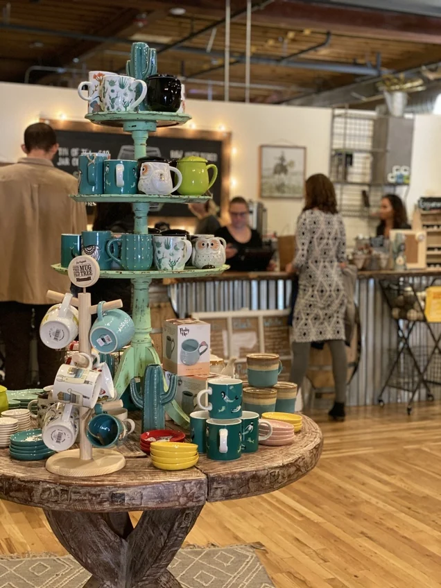 Colorful mugs and wooden display tables inside Old Barrel Tea Company in Golden.