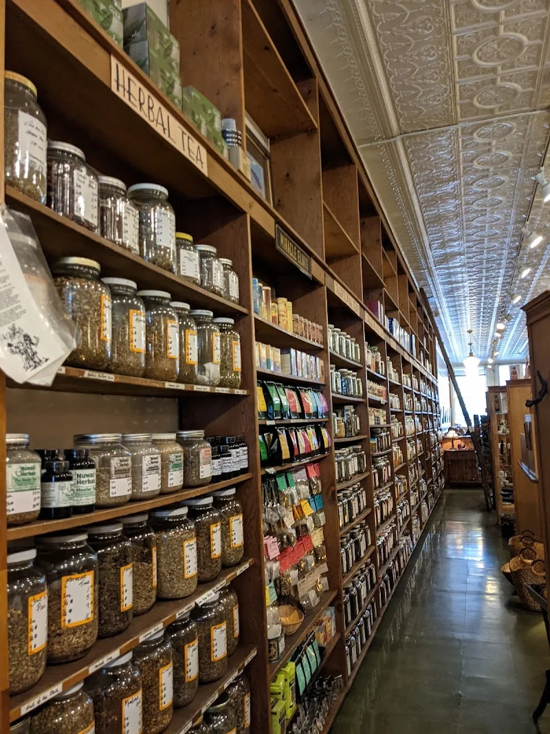 Bulk tea and herb jars lining the wooden shelves inside Butterfly Herbs