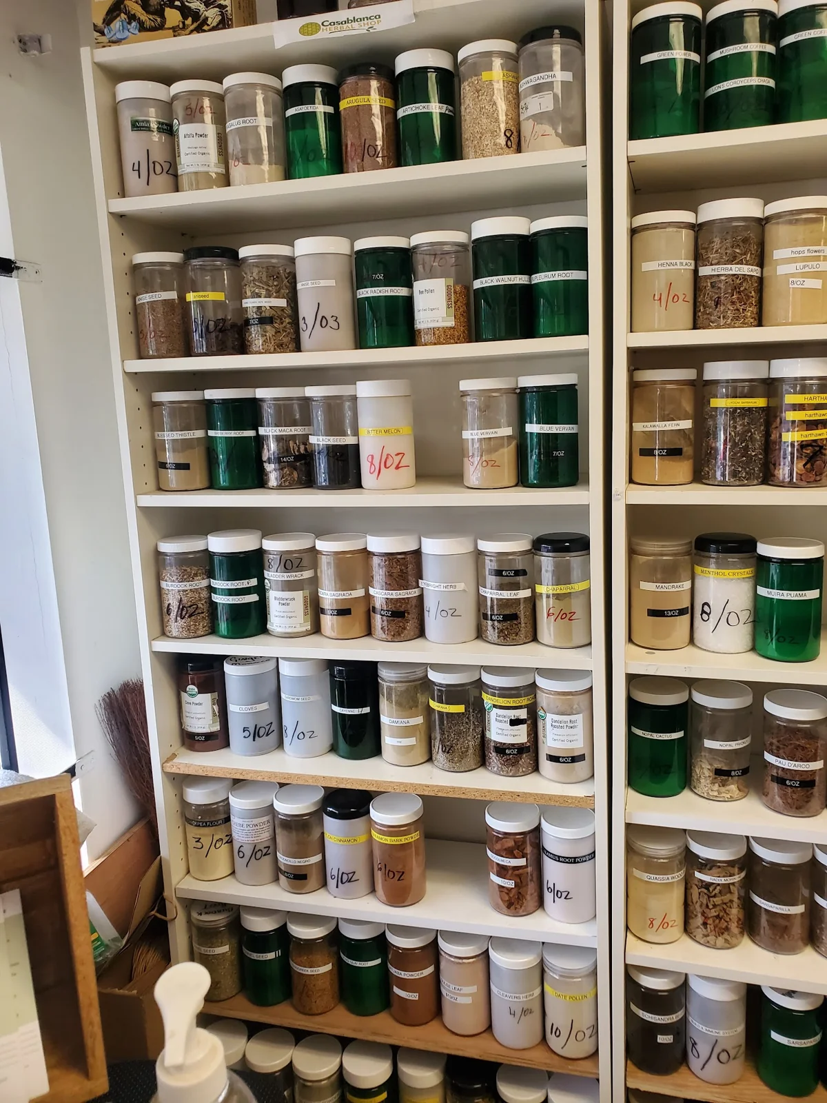 Labeled bulk herb jars beneath a Casablanca Herbal Shop sign