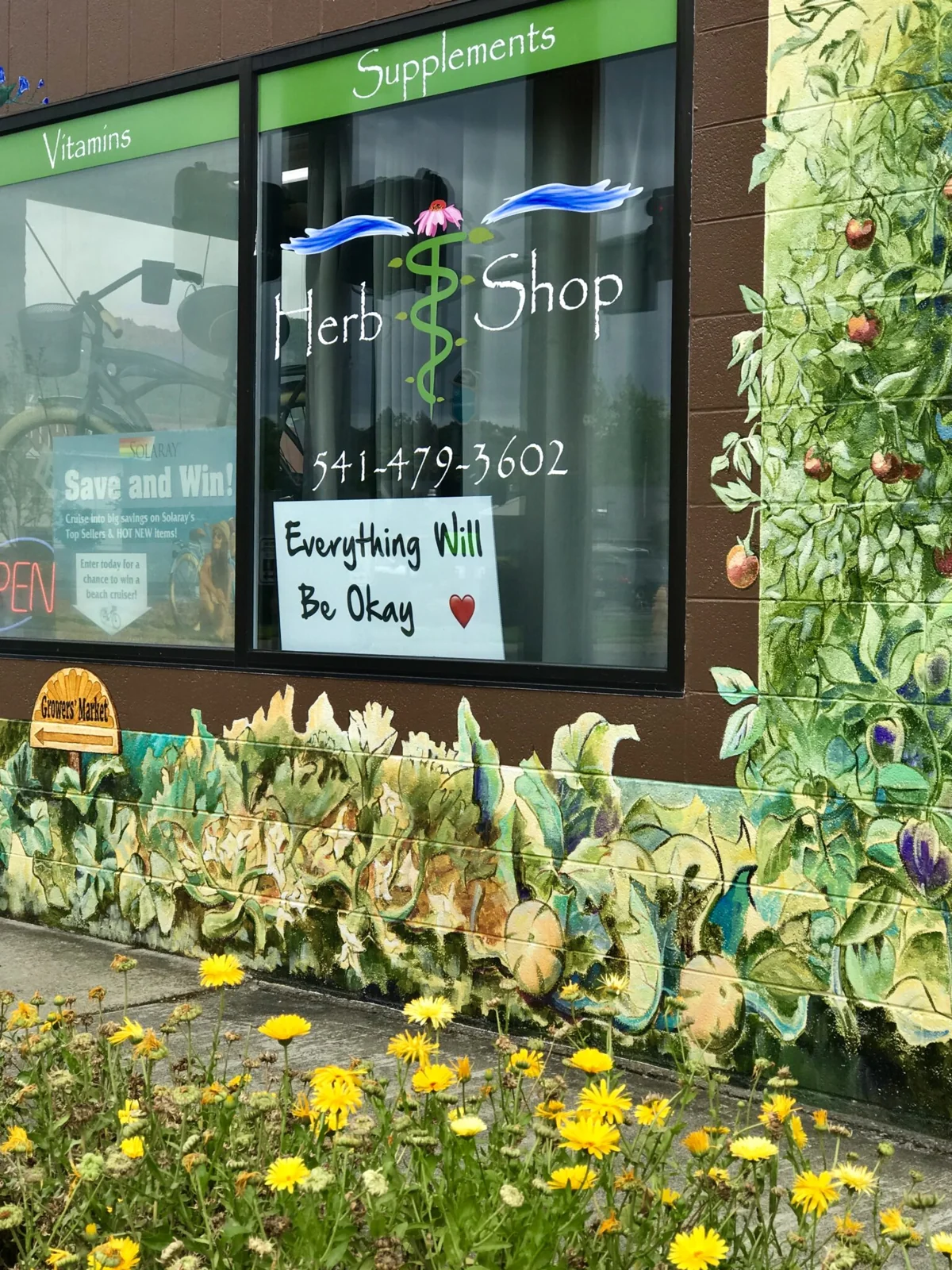 The Herb Shop storefront and floral mural in Grants Pass