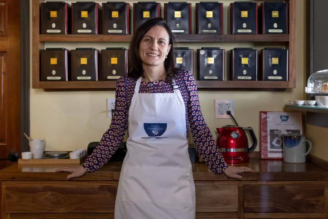 Owner Emilie in front of loose-leaf tea shelves at Centered Spirit