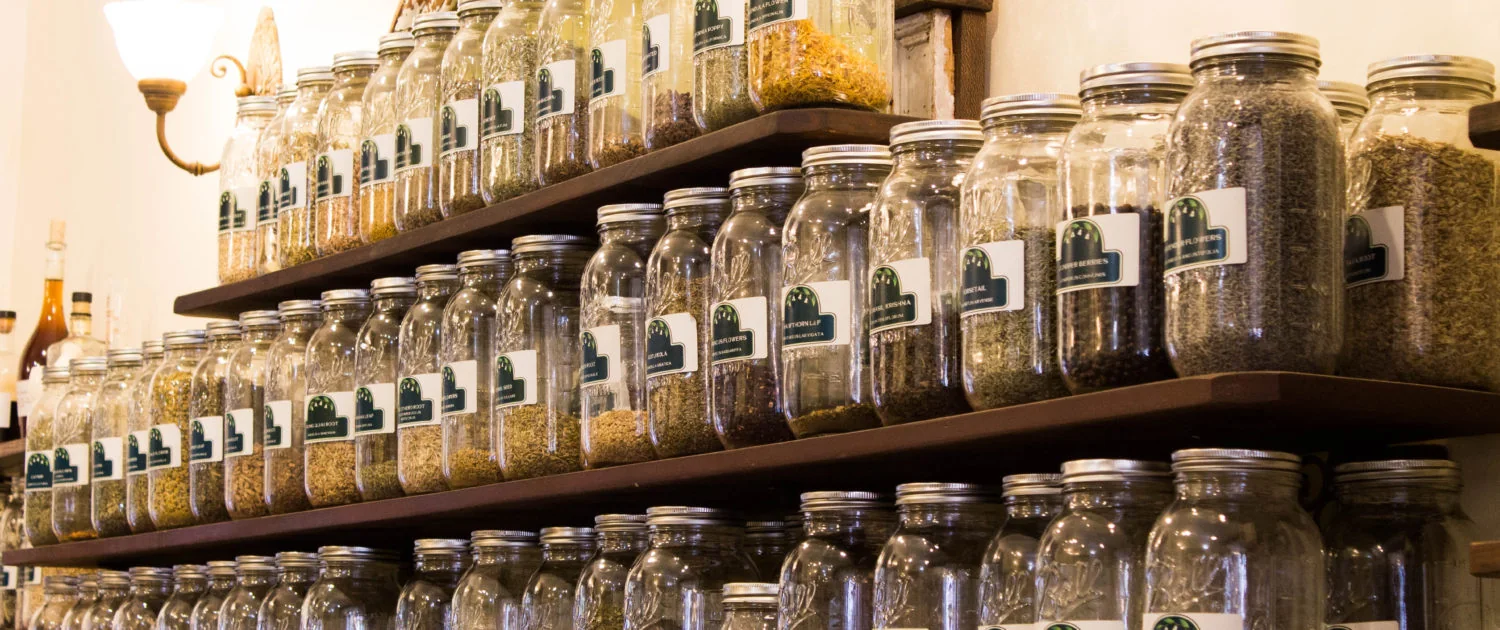 Labeled bulk herb jars on the shelves at Tonic Herb Shop